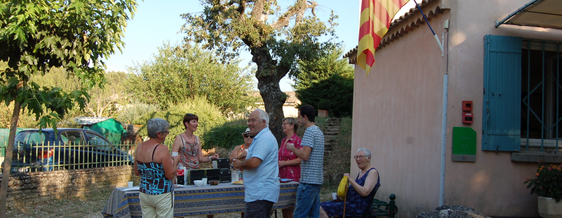 Apéritif de bienvenue du Vue de l'entrée du camping Les Royères du Prieuré de Maubec. Une dizaine de personnes sont présentes