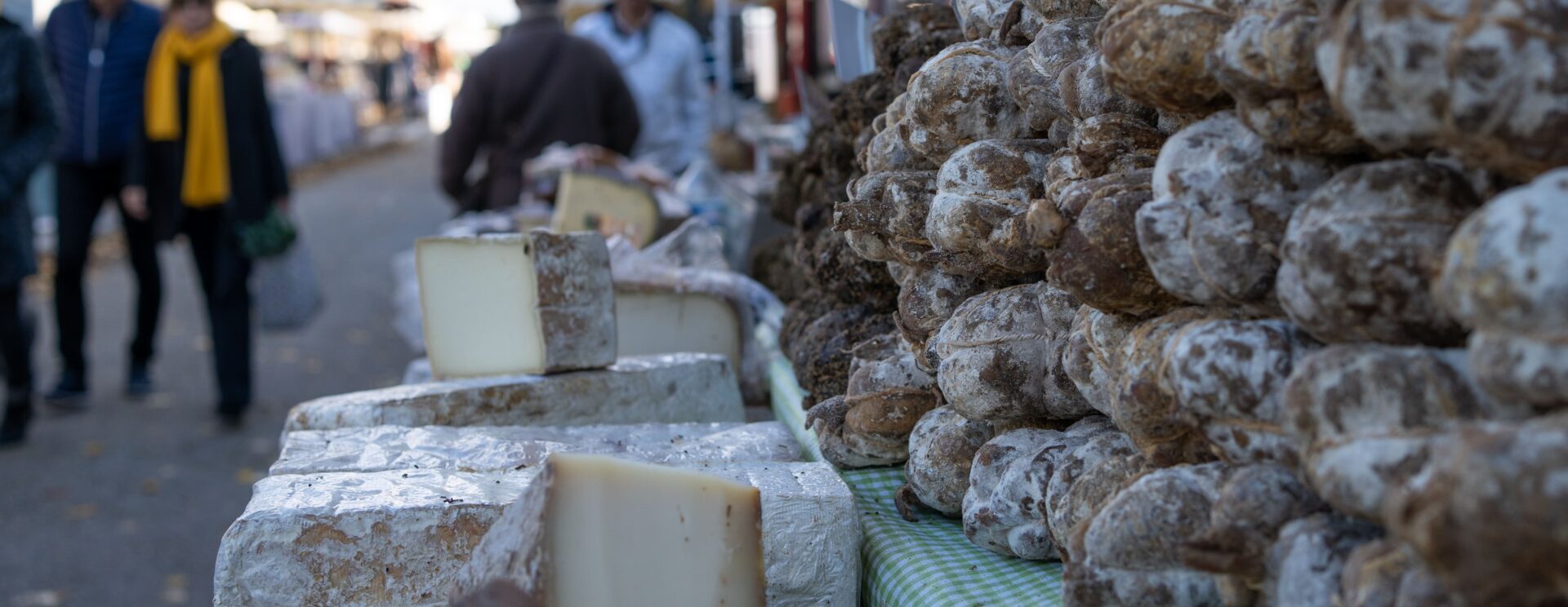 Marché de Coustellet : gros plan d'un étal de charcuterie et fromage