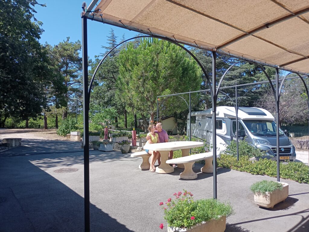 Vue de l'accueil du camping Les Royères du Prieuré de Maubec (accueil et sanitaire) avec en fond. Un couple s'embrasse. - Agrandir l'image, fenêtre modale