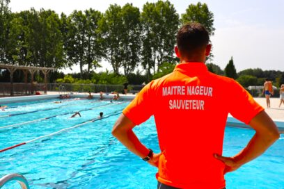 Une maitre nageur sauveteur de dos, face au bassin en sureveillance - Agrandir l'image, fenêtre modale